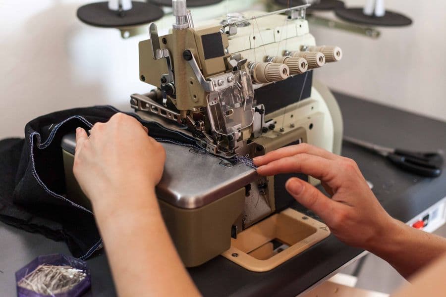 A garment being altered under the needle of a sewing machine