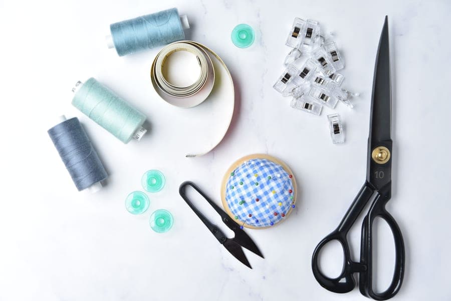 Sewing kit contents laid out - scissors, measuring tape and a pincushion