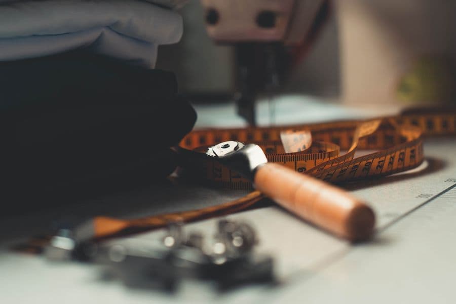 Tailoring tools and folded fabric laid out on a workbench