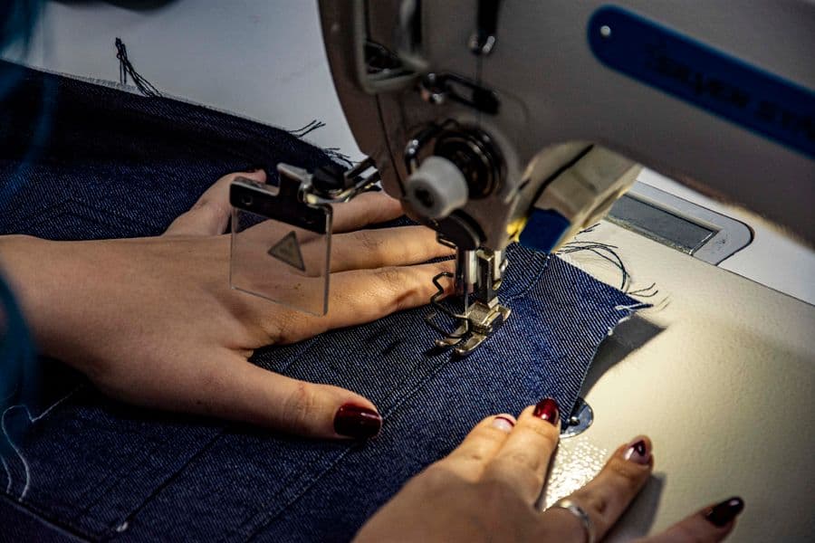 Denim fabric being stitched on a sewing machine