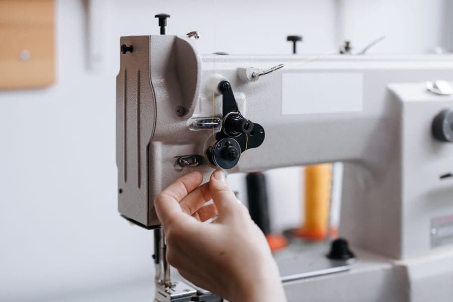 Cleaning the bobbin area of a sewing machine with a small brush
