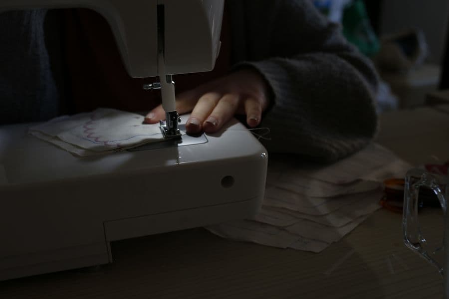Fabric being fed through the arm of a sewing machine