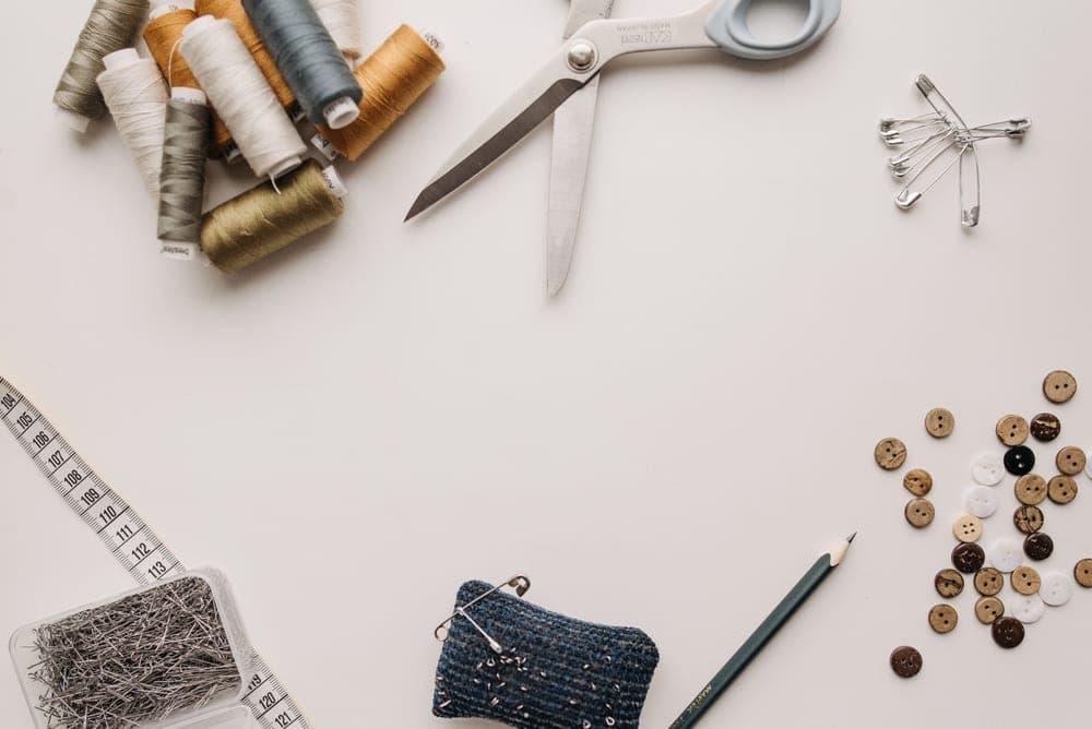 Sewing supplies, fabric and scissors laid out on a table
