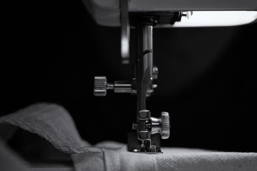 A simple mechanical sewing machine photographed on a plain table