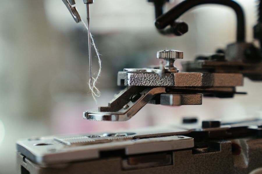 Threading the top thread through the guides of a sewing machine
